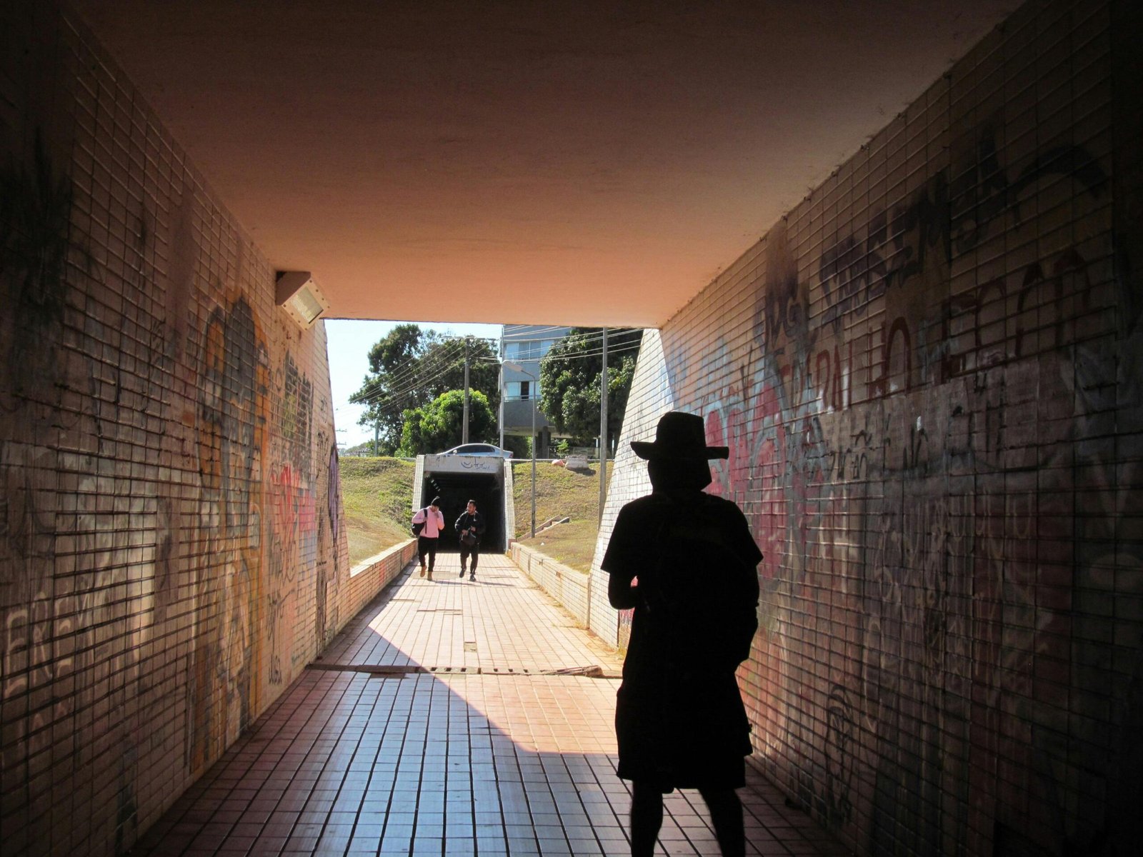 Silhouetted figure in a tunnel leading outdoors in Brasília, Brazil.